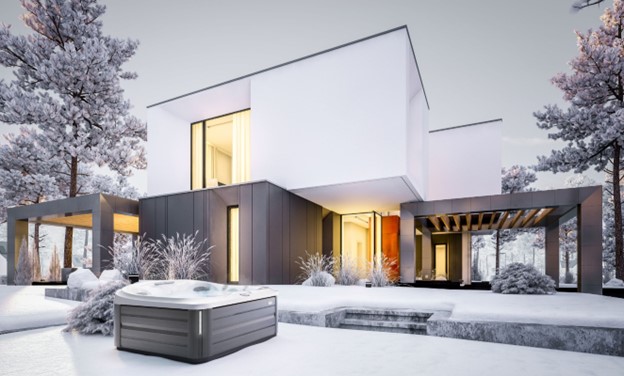 Winterizing your hot tub - Jacuzzi hot tub with modern house in the background during winter