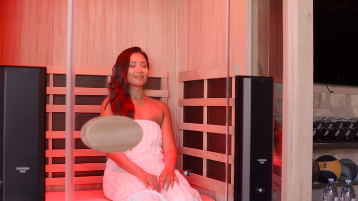 woman in a home sauna with a red light